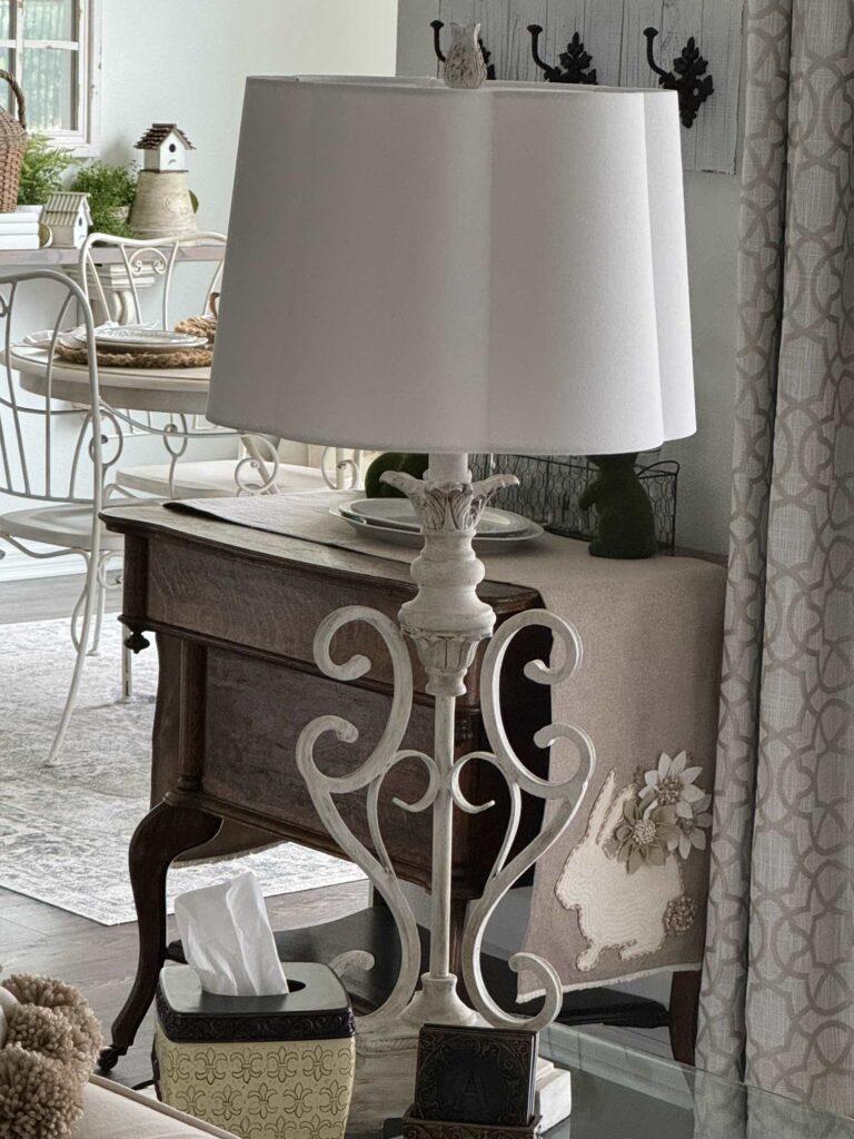 A white lamp with a white scalloped lamp shade. 