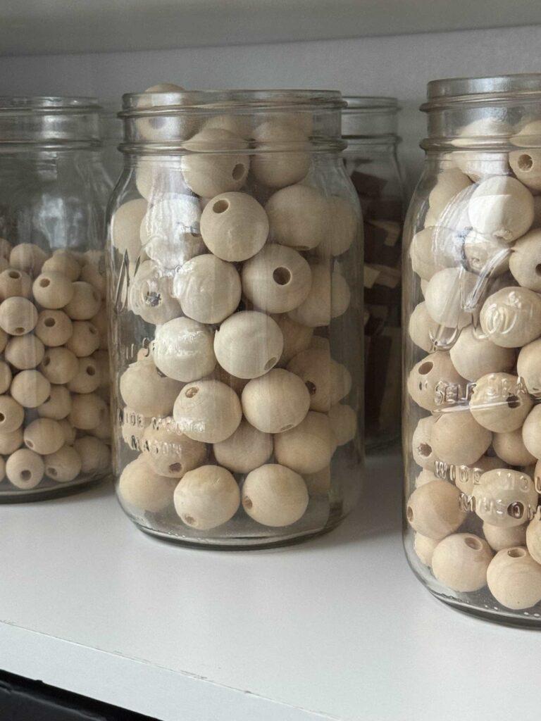 Craft room organization tip #5 is to store wood beads in mason jars.  