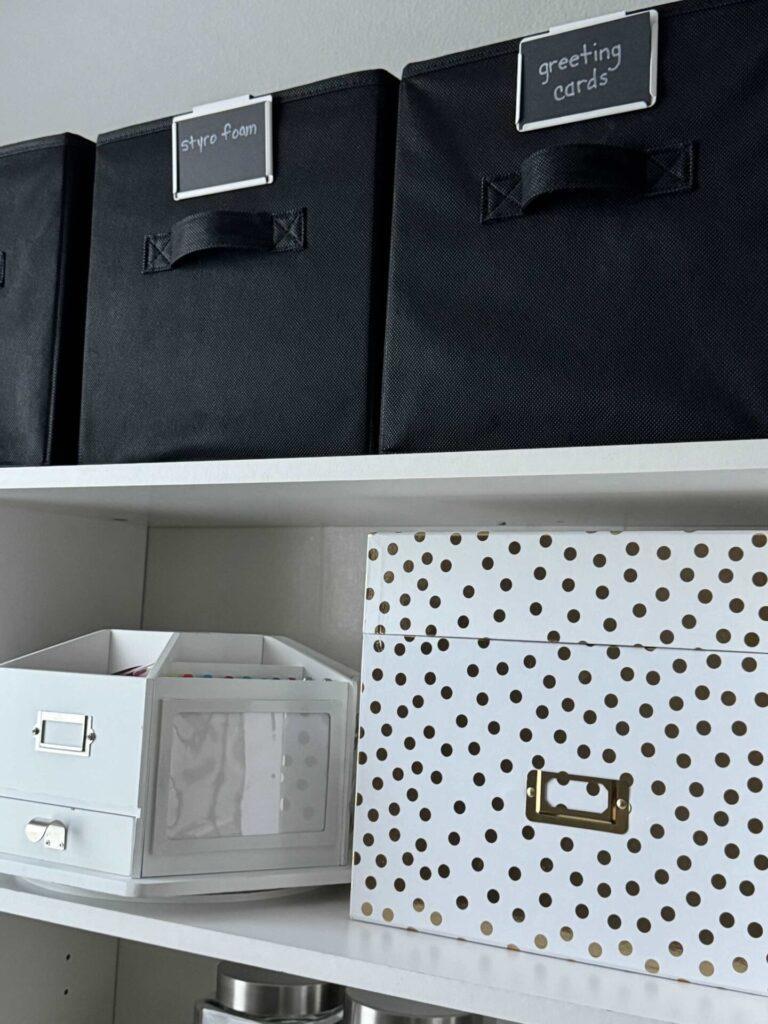 Craft room organization tip #7 is to use fabric storage cubes, a decorative box, and a lazy Susan on bookshelves for storage.  