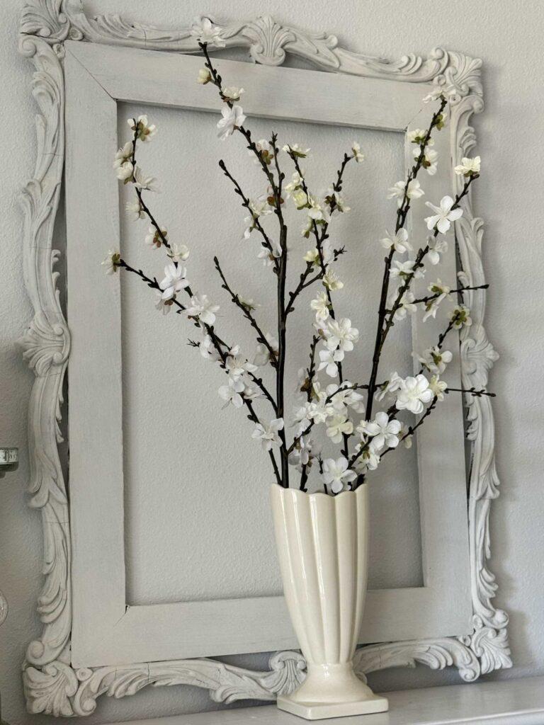 Spring flowering branches in an ivory vase on a mantel. 