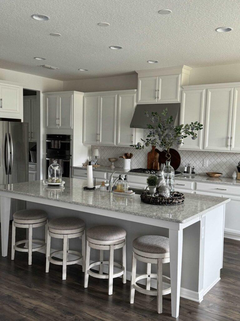 A white kitchen that lacks pendant lights. 