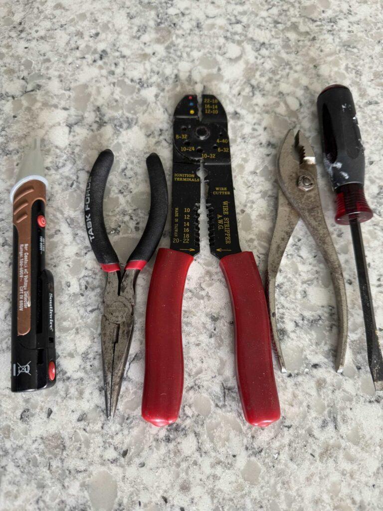 Tools needed to hang pendant lights laying on a counter. 