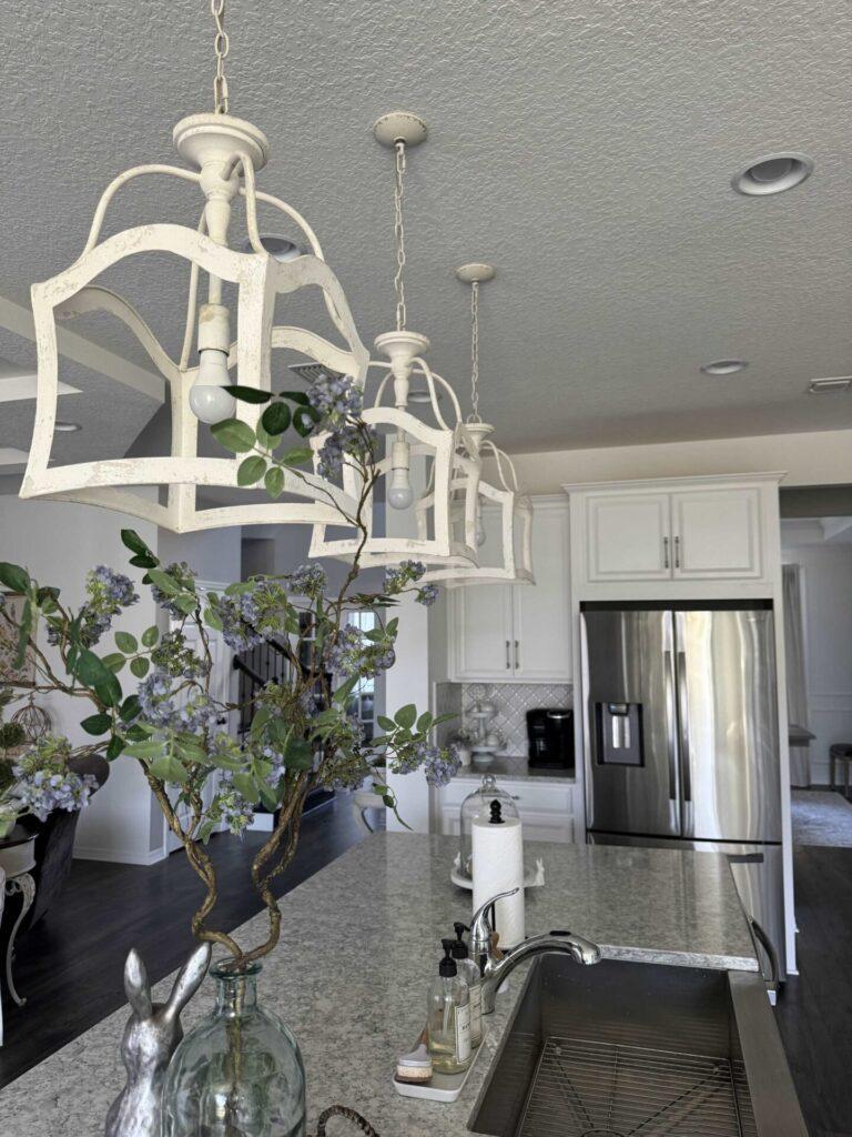 Three white pendant lights hanging in a kitchen. 