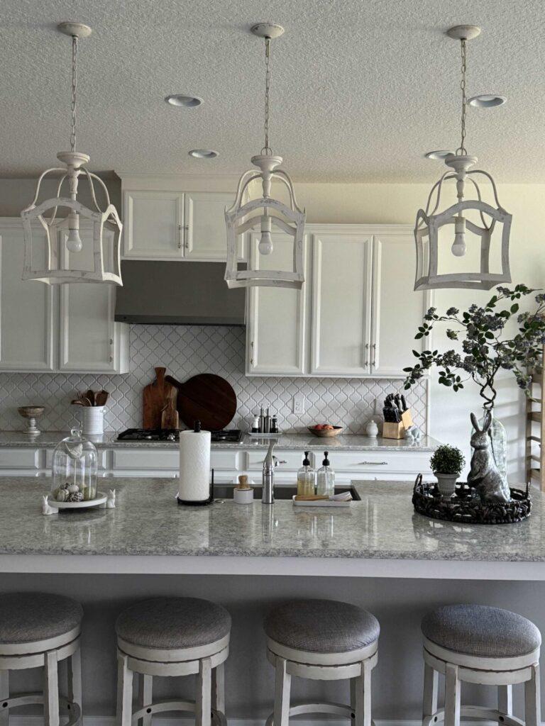 Three pendant lights hanging over a kitchen island. 