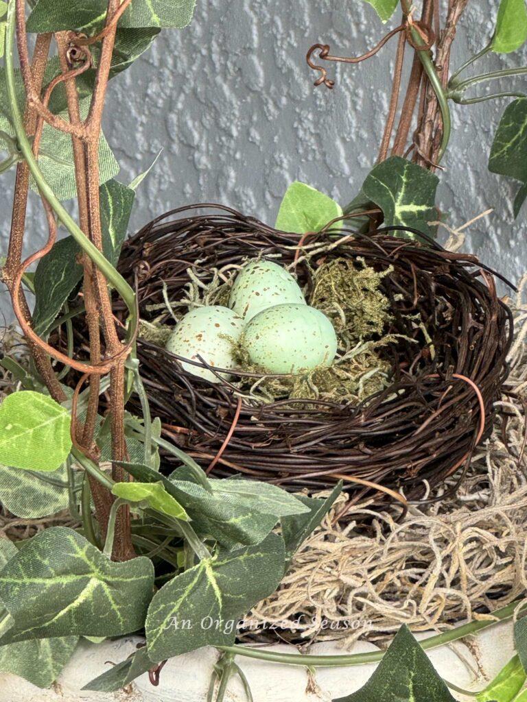 A faux bird's nest with three blue eggs. 