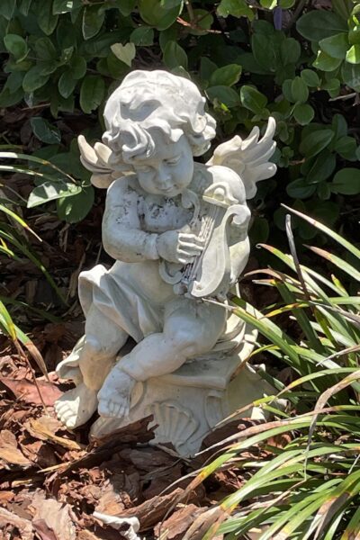 Outdoor angel statue in mulched flower bed