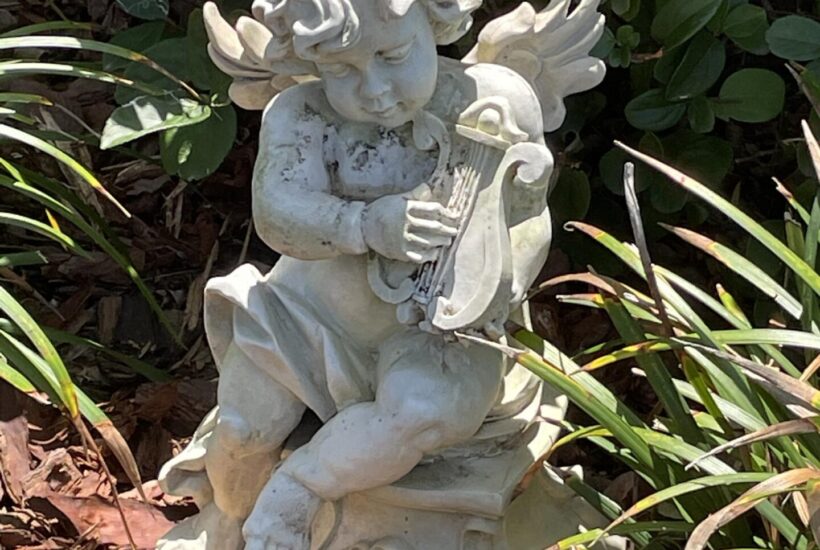 Outdoor angel statue in mulched flower bed
