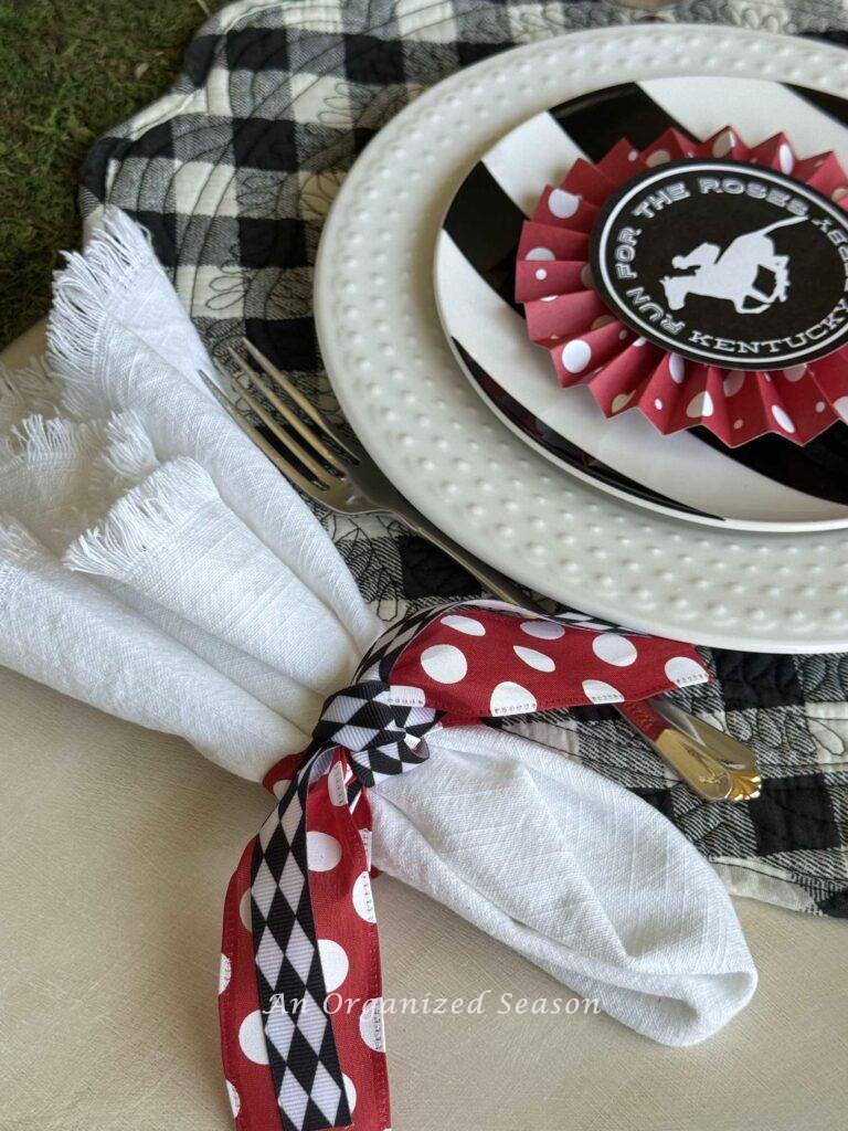 White napkin wrapped with two coordinating ribbons.