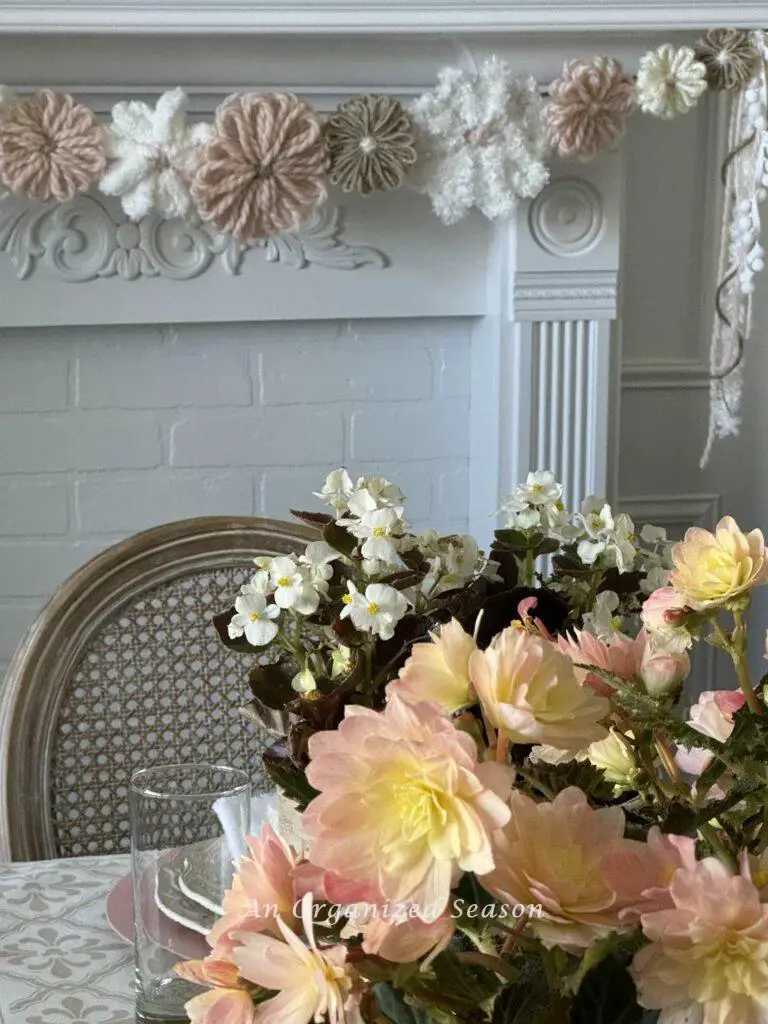 A yarn flower garland hanging on a mantel in a dining room. 