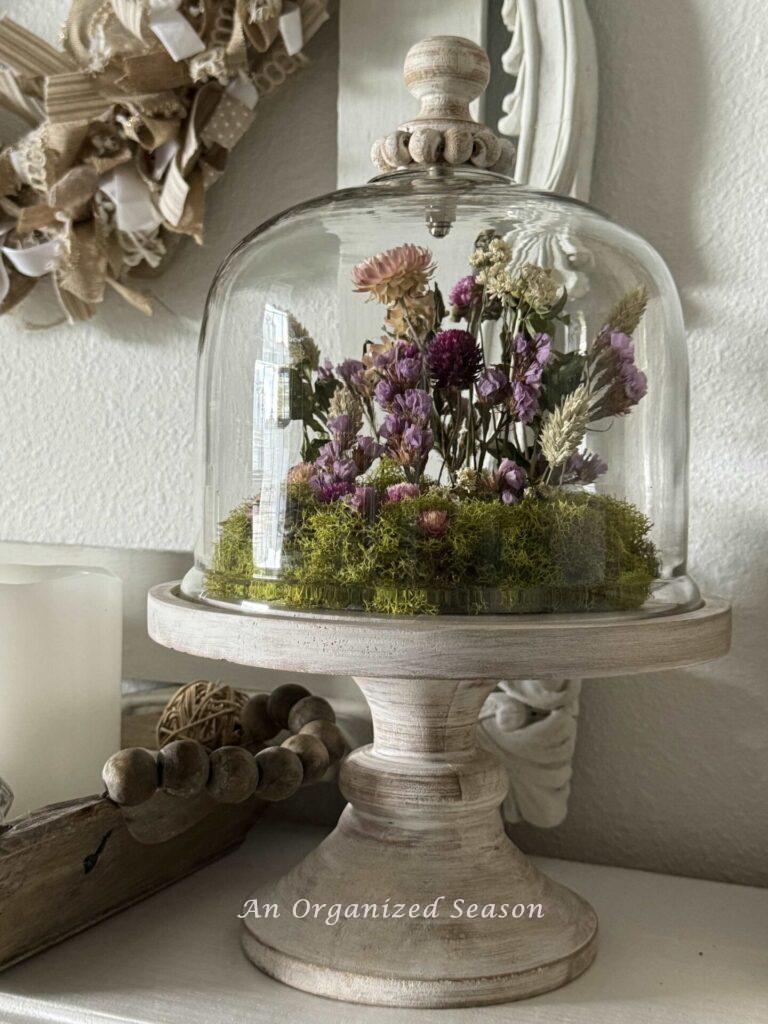 Floral arrangement in a glass cloche.