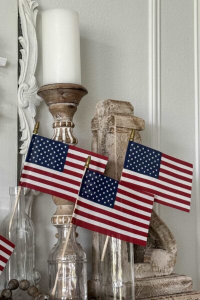 American flags in glass jars on a mantel.