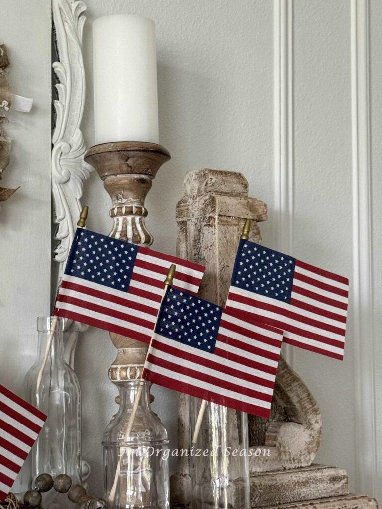 Place flags in clear flower vases to add patriotic decor to a mantel.