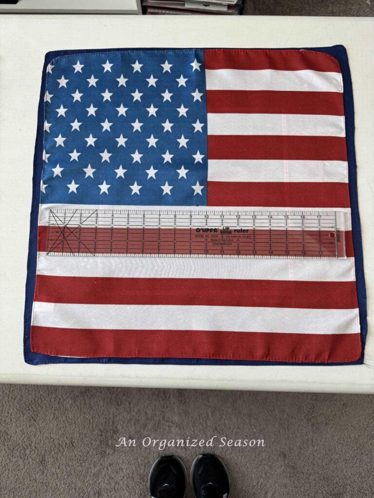 A flag bandana with a clear 18-inch ruler laying on it. 