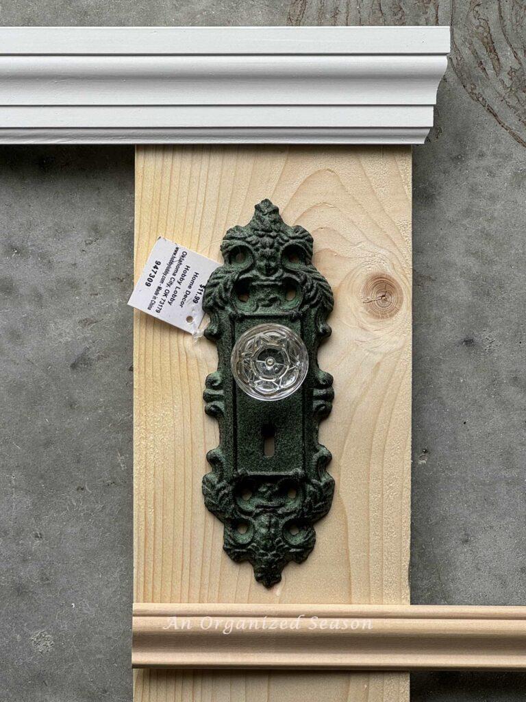 a green door knob, a piece of wood, and two trim pieces. 