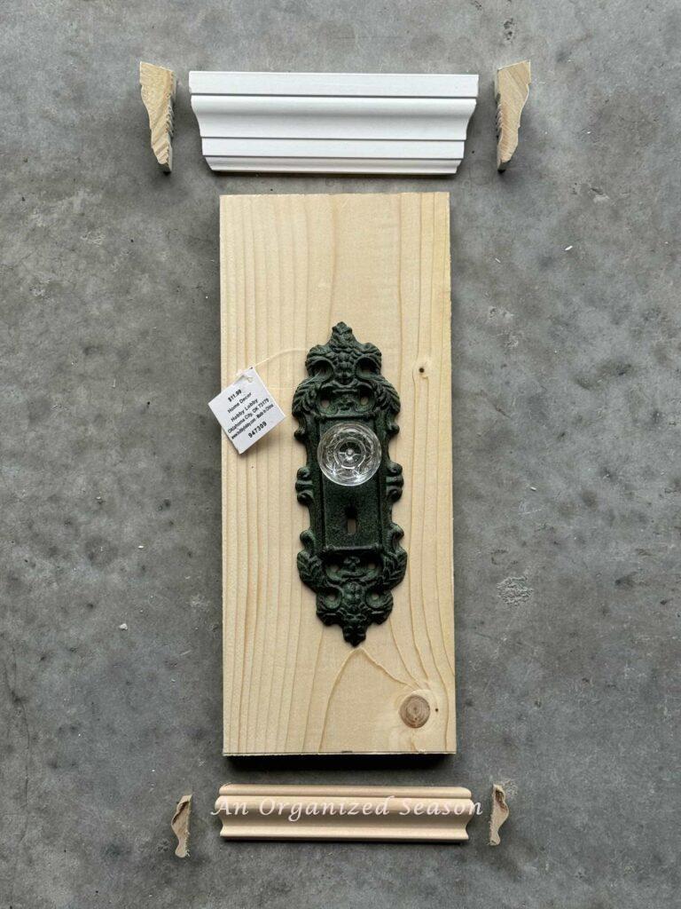A green door knob and pieces of trim and wood. 