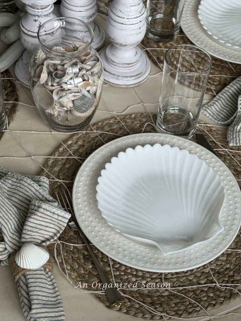 A white shell salad plate on a white dinner plate.