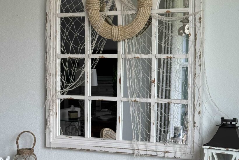 A coastal DIY rope wreath hanging on a mirror draped with a fishing net.