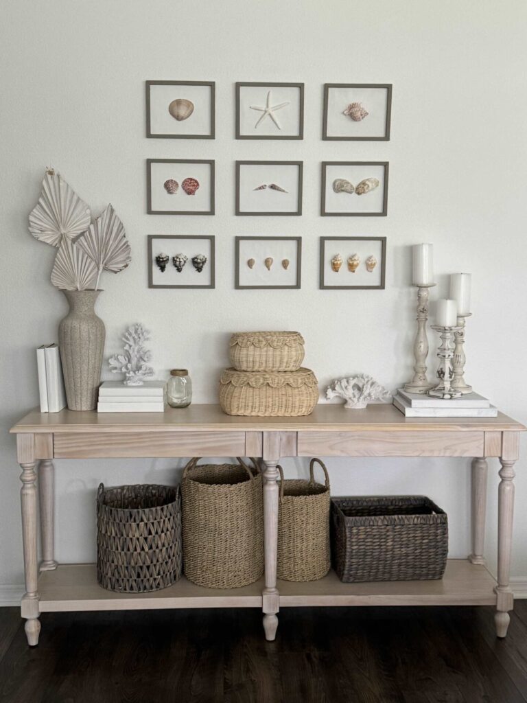 Seashell art gallery hanging above a console table. 