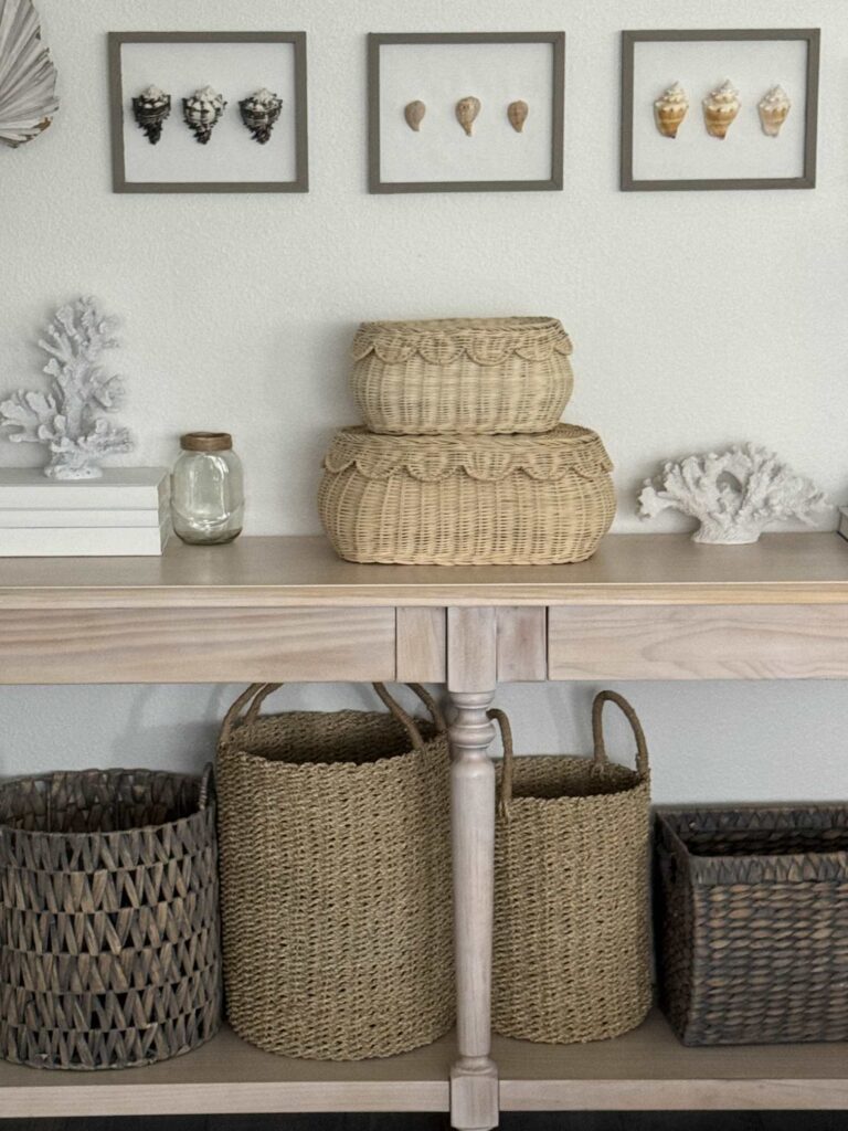 Three seashell pictures hanging over a console table. 