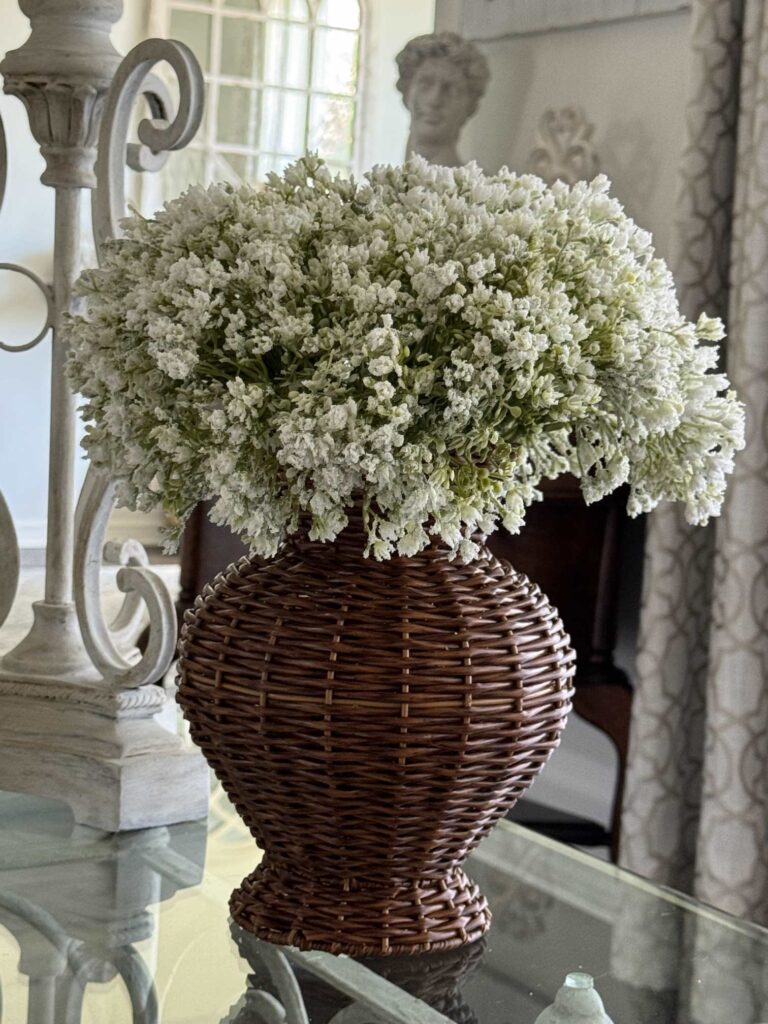 A rattan vase filled with babies breath. 