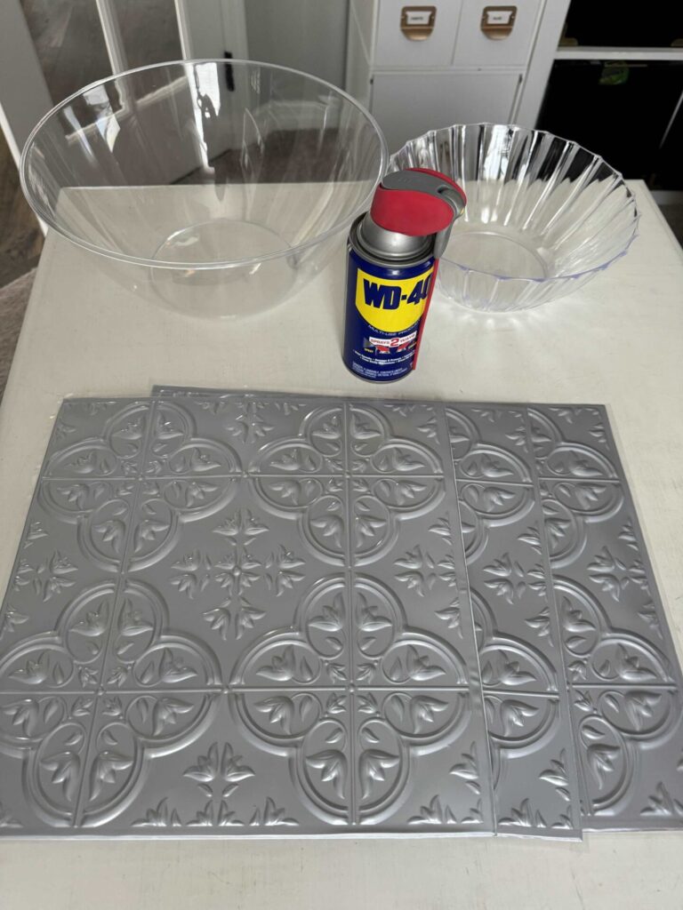 Two plastic bowls, faux tiles, and WD-40 to make DIY concrete bowls. 