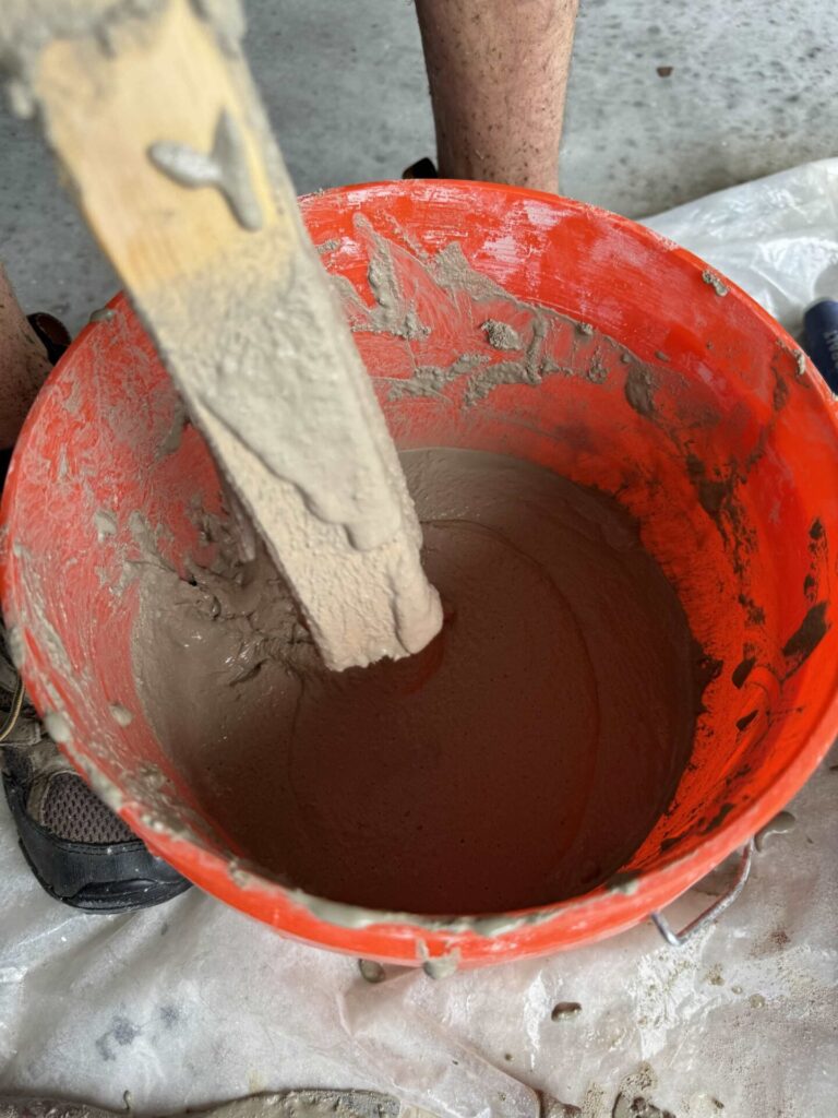 Someone stirring concrete in a bucket.