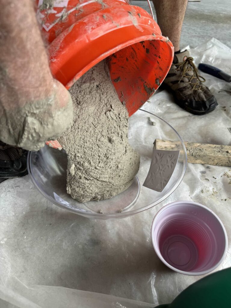 A man pouring concrete into a clear plastic bowl. 