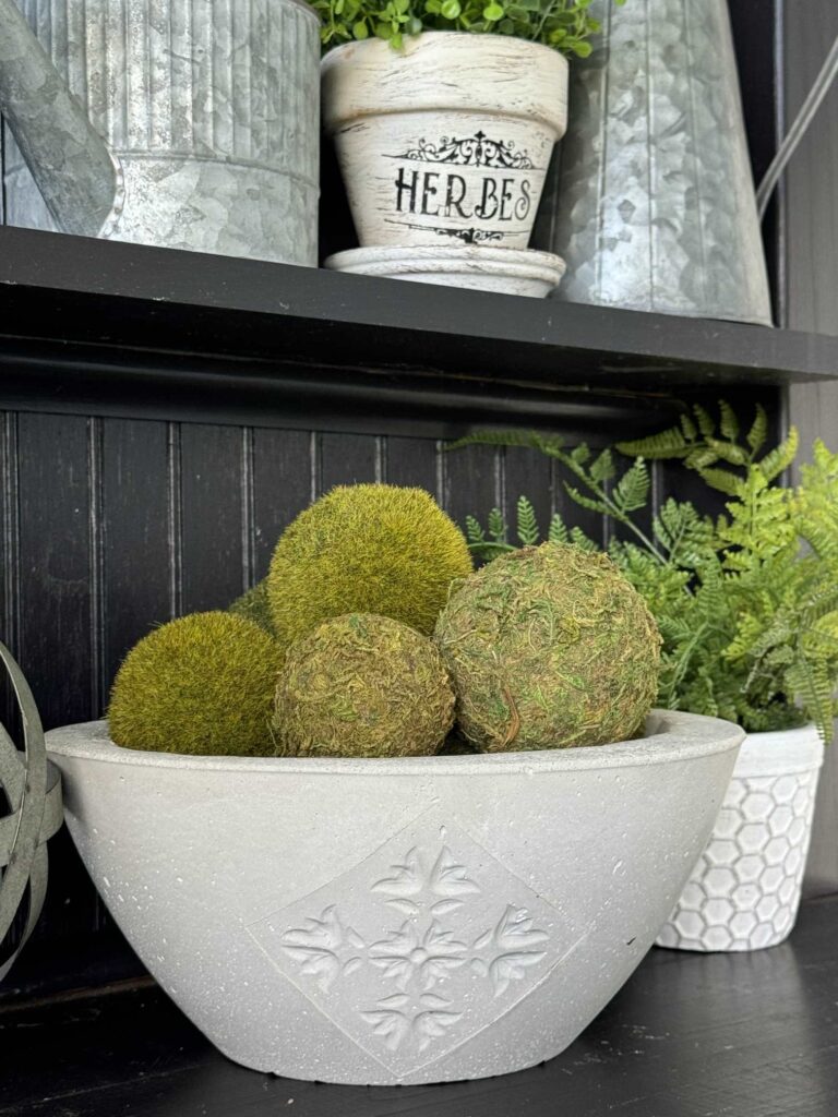 A DIY concrete bowl filled with moss balls.