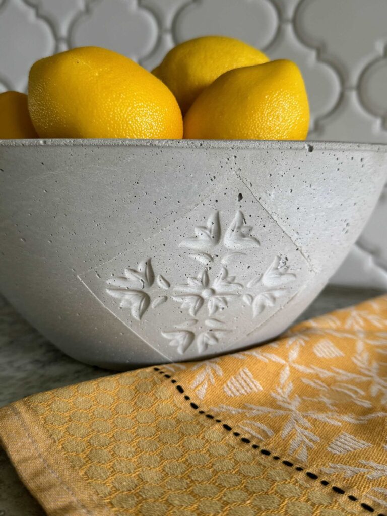 A DIY concrete bowl filled with lemons.