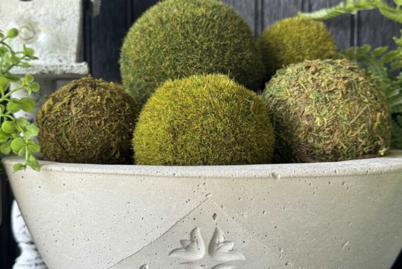 A DIY concrete bowl filled with moss balls.
