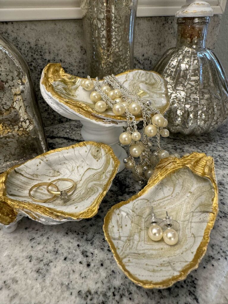 Decoupaged oyster shells holding jewelry. 