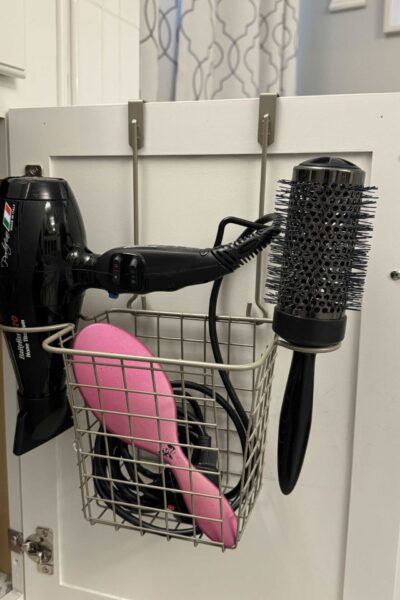 Hair tool organizer hanging on a bathroom cabinet door.