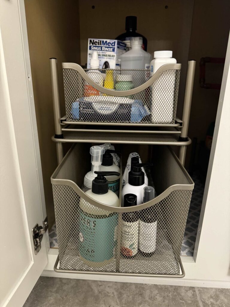 Stackable wire mesh pull out drawers organized in a bathroom cabinet. 