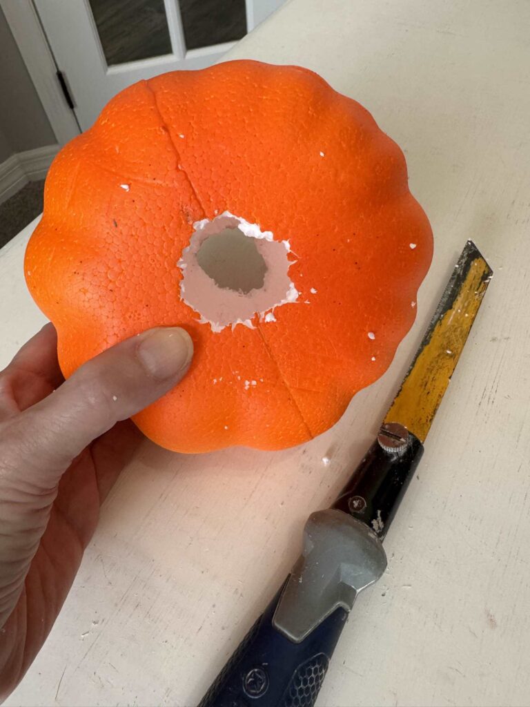 Someone cut a hole through a Dollar Tree foam pumpkin. 