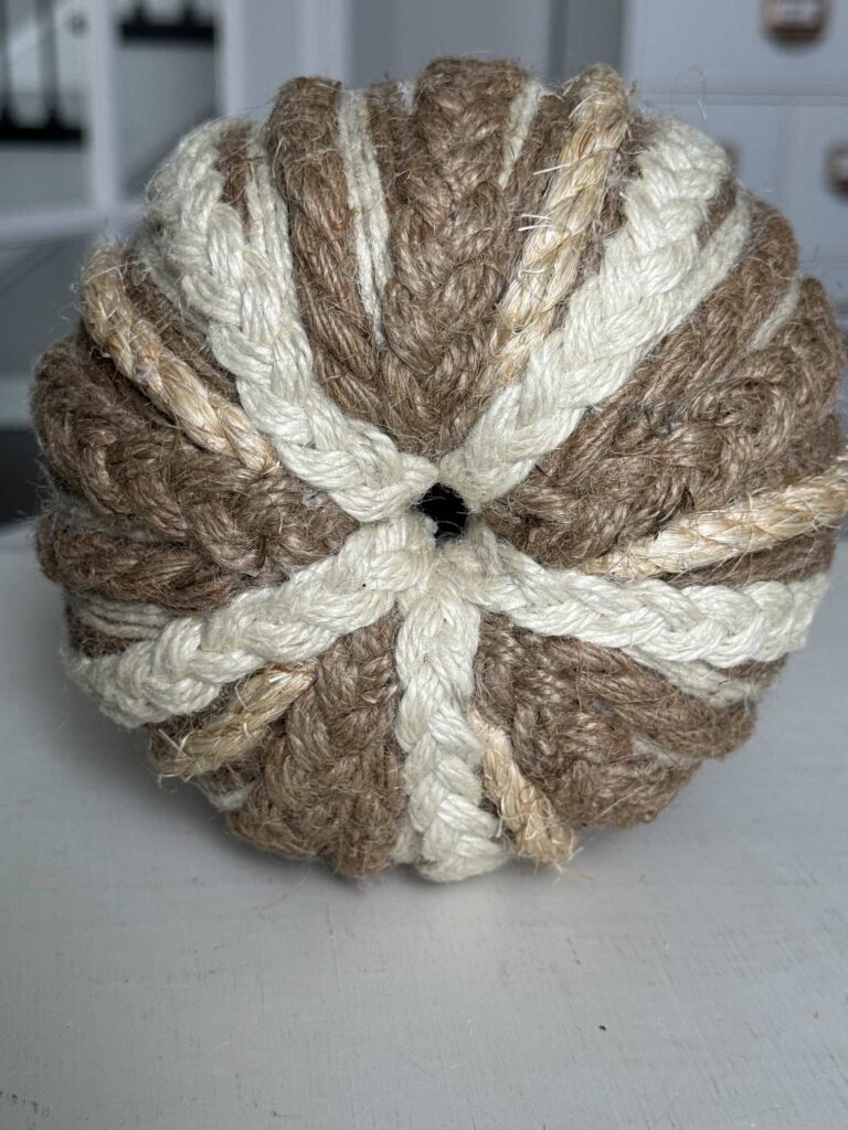 The top of a pumpkin wrapped with rope and twine. 