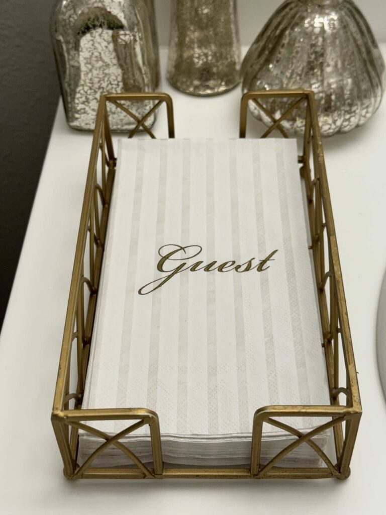 Disposable guest towels in a gold tray. 