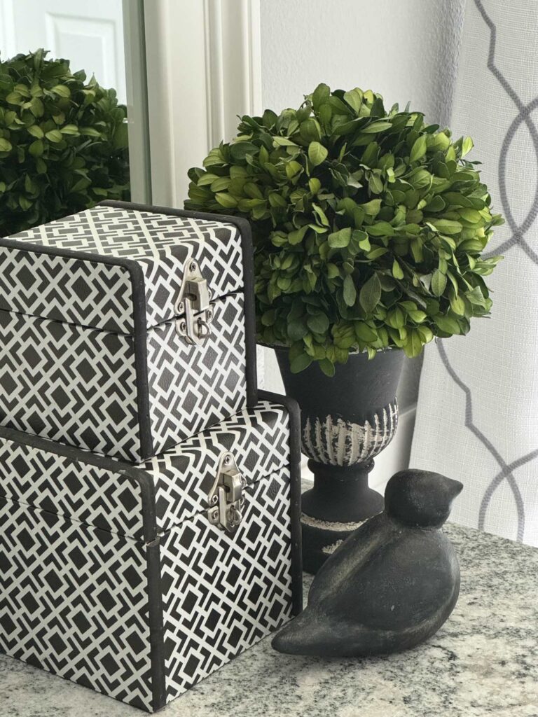 Stacked black and white boxes on a bathroom counter. 