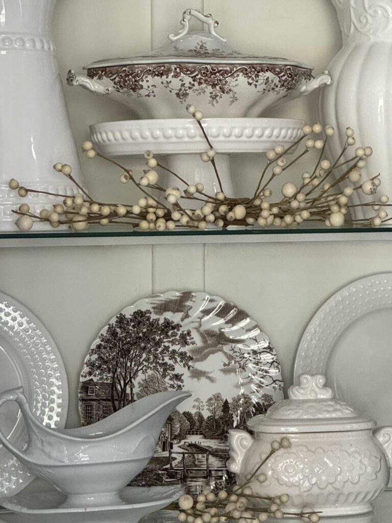 Brown transferware dishes in a China cabinet work beautifully for fall decorating.