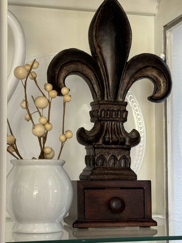 A brown wood Fleur-de-Lis statue. 