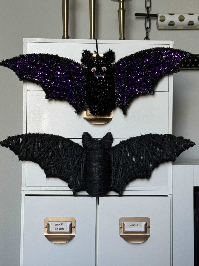 A Dollar Tree tinsel bat hanging above a DIY Halloween bat made to look like one at Pottery Barn.  