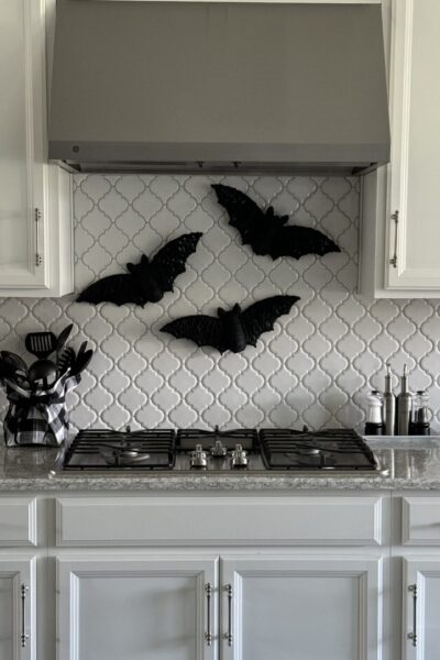 Three DIY Halloween bats hanging over a stove.