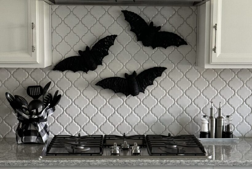 Three DIY Halloween bats hanging over a stove.