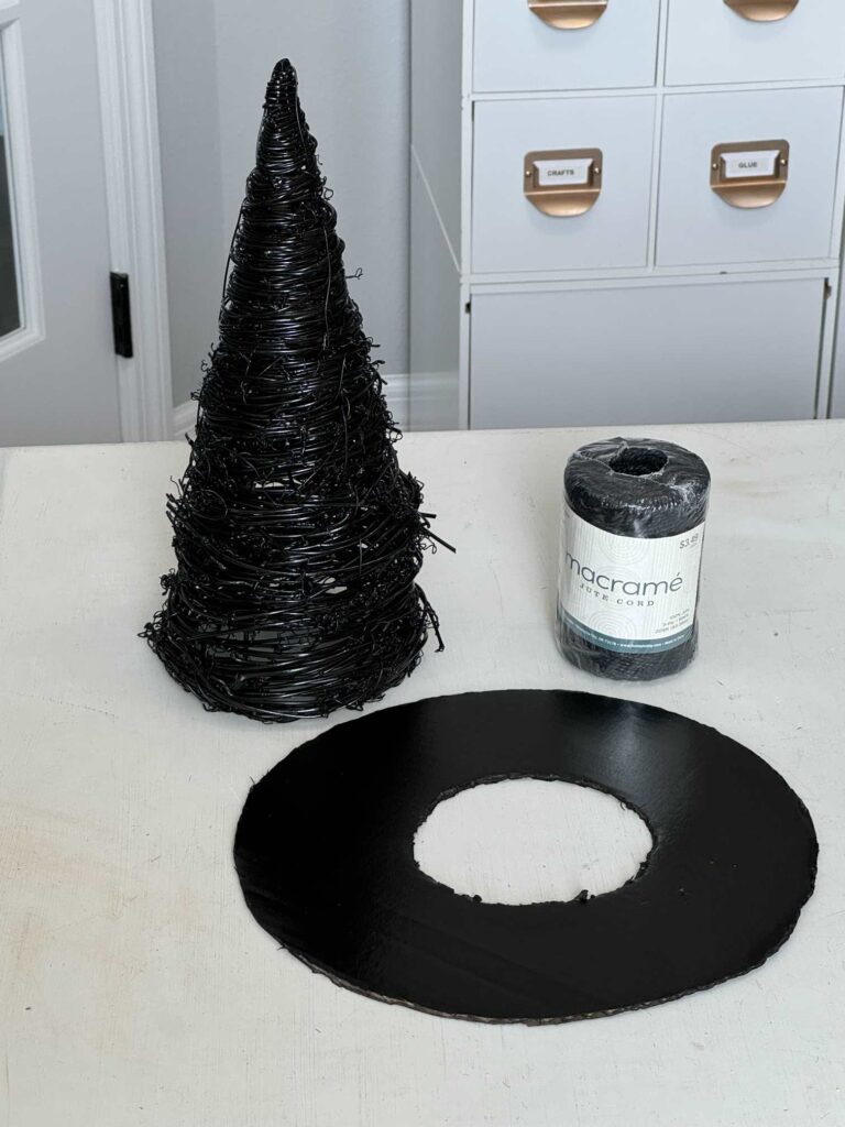 Black macrame cord, a black twine cone tree, and a black cardboard circle. 