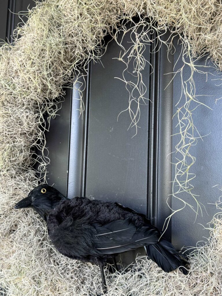 A wreath with a black crow on it. 