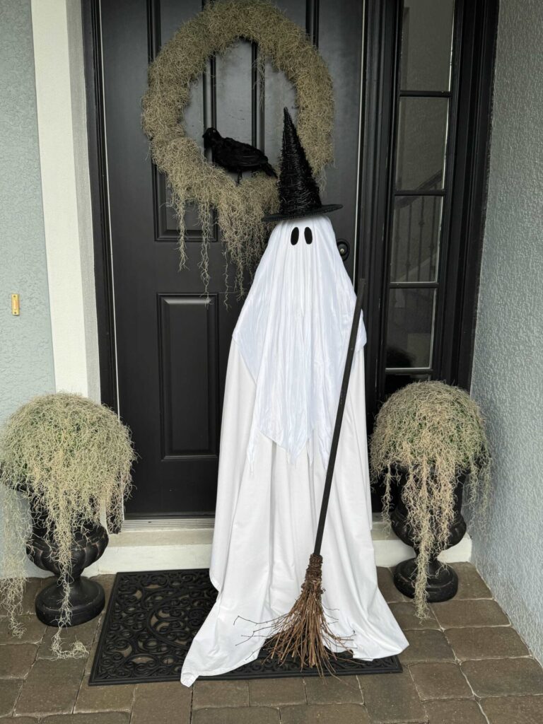 A Pottery Barn DIY witch ghost on a front porch. 