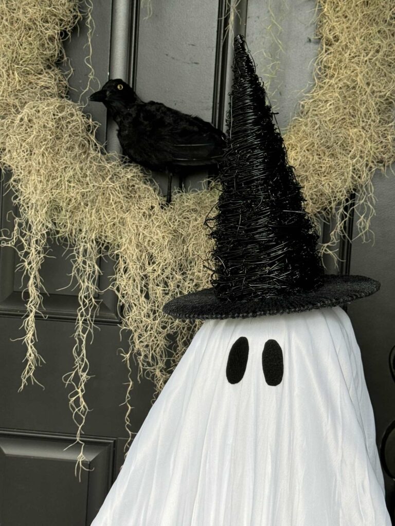 The head of a DIY ghost wearing a witch hat. 