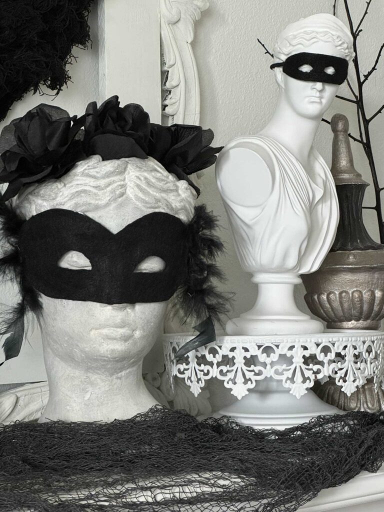 Two busts wearing black masks. 