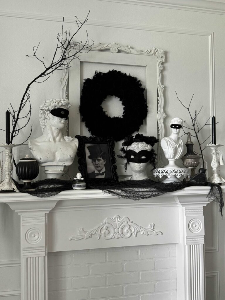 An elegant Halloween mantel decorated with black and white items. 