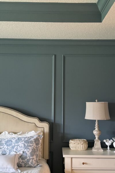 Bedroom with blue walls and wood moldings.