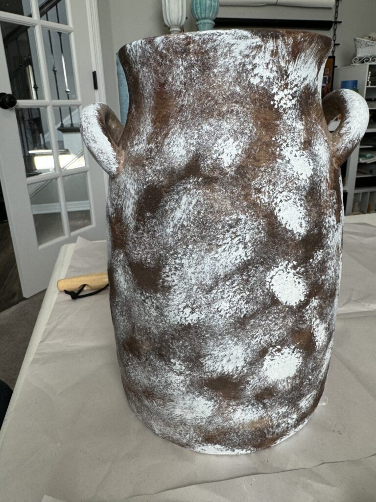 White paint dabbed on a brown vase. 